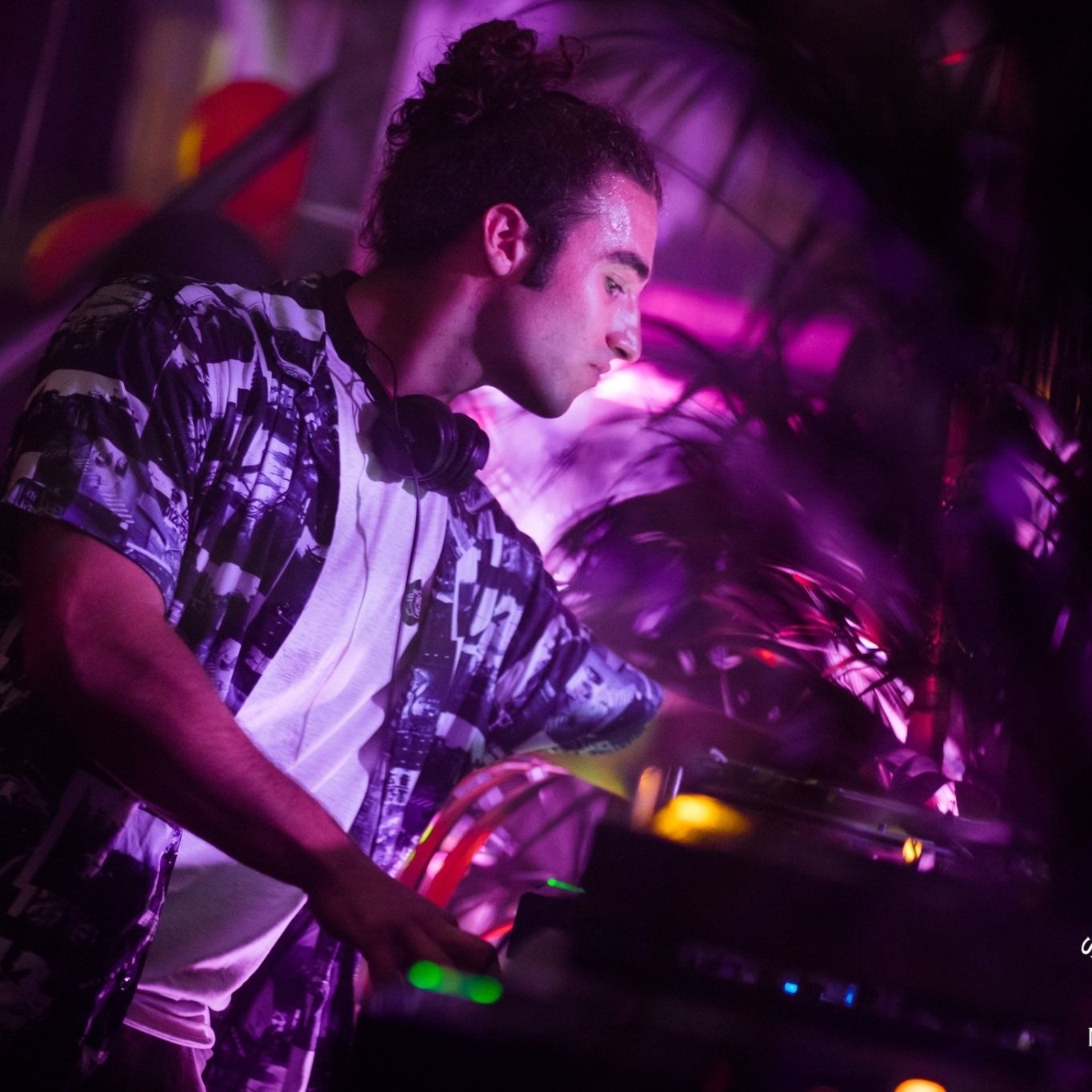 DJ Proni performing in a club under purple lights